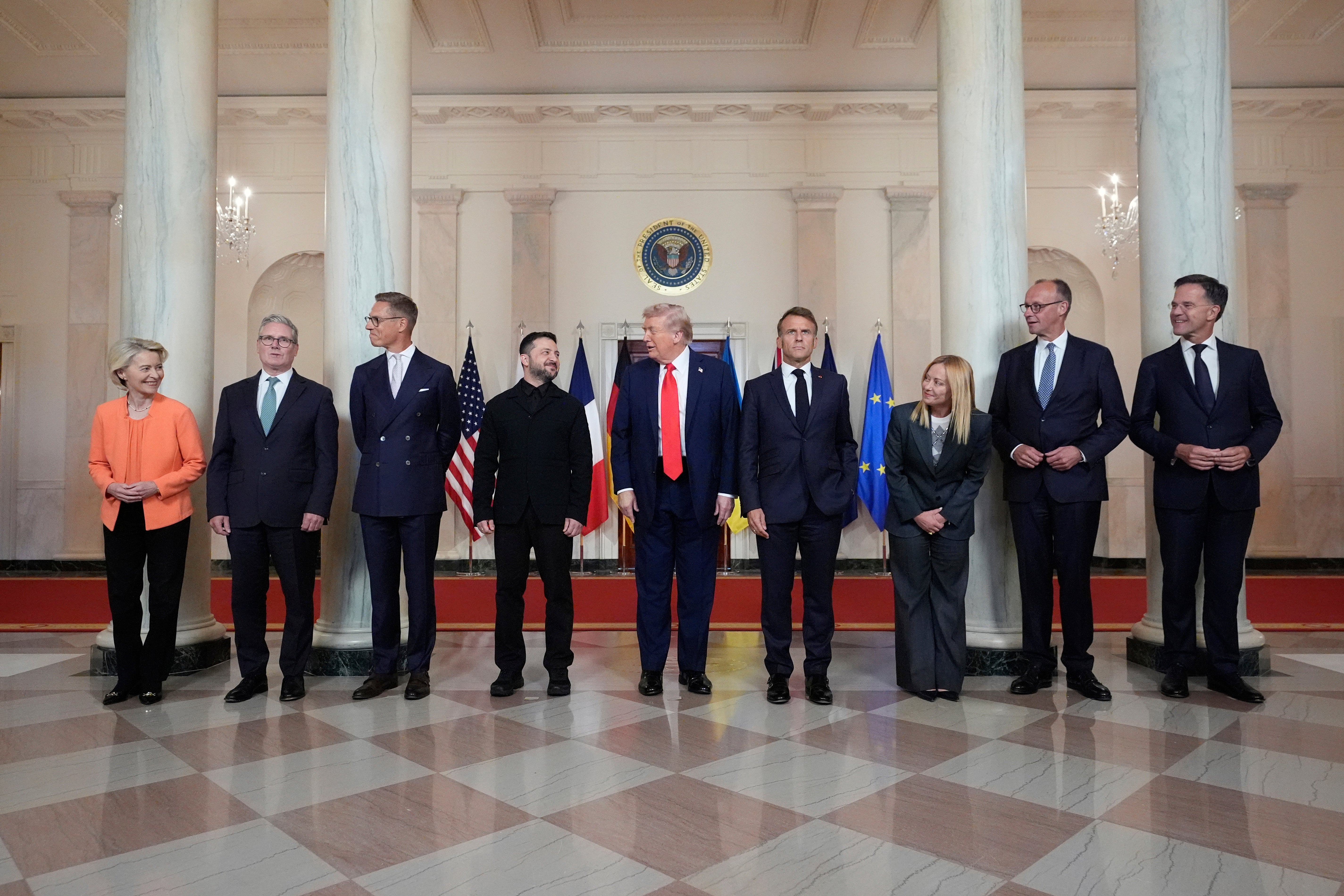 European Commission President Ursula von der Leyen, from left, British Prime Minister Keir Starmer, Finland's President Alexander Stubb, Ukrainian President Volodymyr Zelenskyy, President Donald Trump, France's President Emmanuel Macron, Italy's Prime Minister Giorgia Meloni, Germany's Chancellor Friedrich Merz and NATO Secretary General Mark Rutte stand before a group photo in the Grand Foyer of the White House, Monday, Aug. 18, 2025, in Washington. (AP Photo/Alex Brandon)