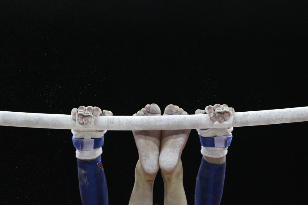 A gymnast practices on the uneven bars during a training session before the Olympic gymnastics venue test event in east Lo...