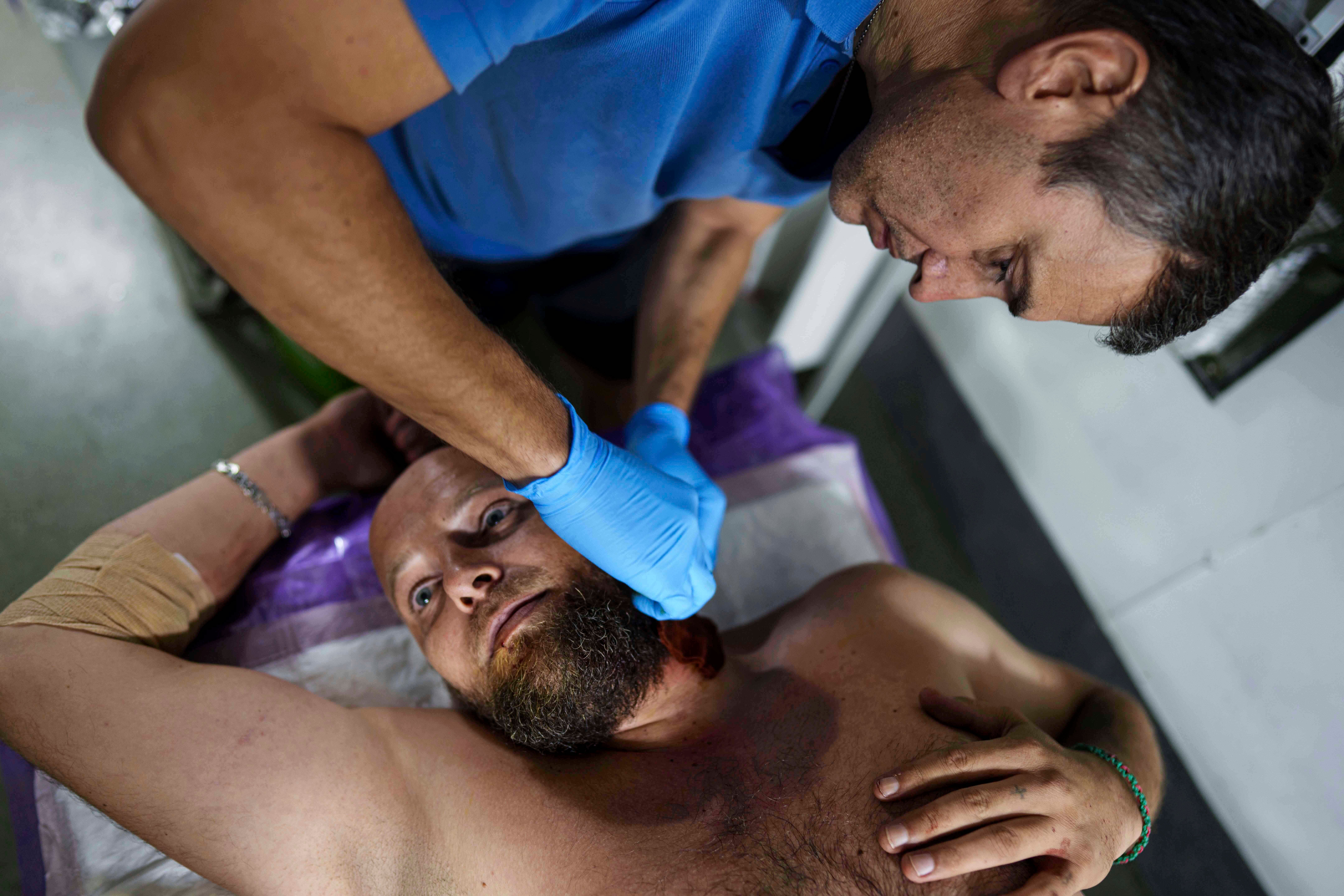 A Ukrainian military medic of 59th brigade treats his injured comrade at a stabilisation point not far from the frontline on Pokrovsk direction, Ukraine, Saturday, Aug. 9, 2025. (AP Photo/Evgeniy Maloletka)