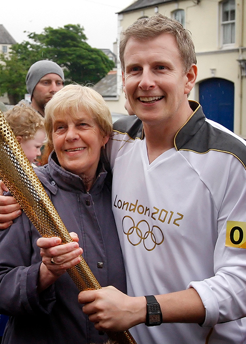 File photo dated 07/06/12 of Patrick Kielty holding the Torch with his mother Mary before he completes his leg through his hometown of Dundrum on Day 20 of the London 2012 Olympic Torch Relay. The funeral of Mary Kielty who died on March 8, is taking place at the Church of the Sacred Heart in Dundrum. Picture date: Monday March 10, 2025. PA Photo. See PA story FUNERAL Kielty. Photo credit should read: Danny Lawson/PA Wire