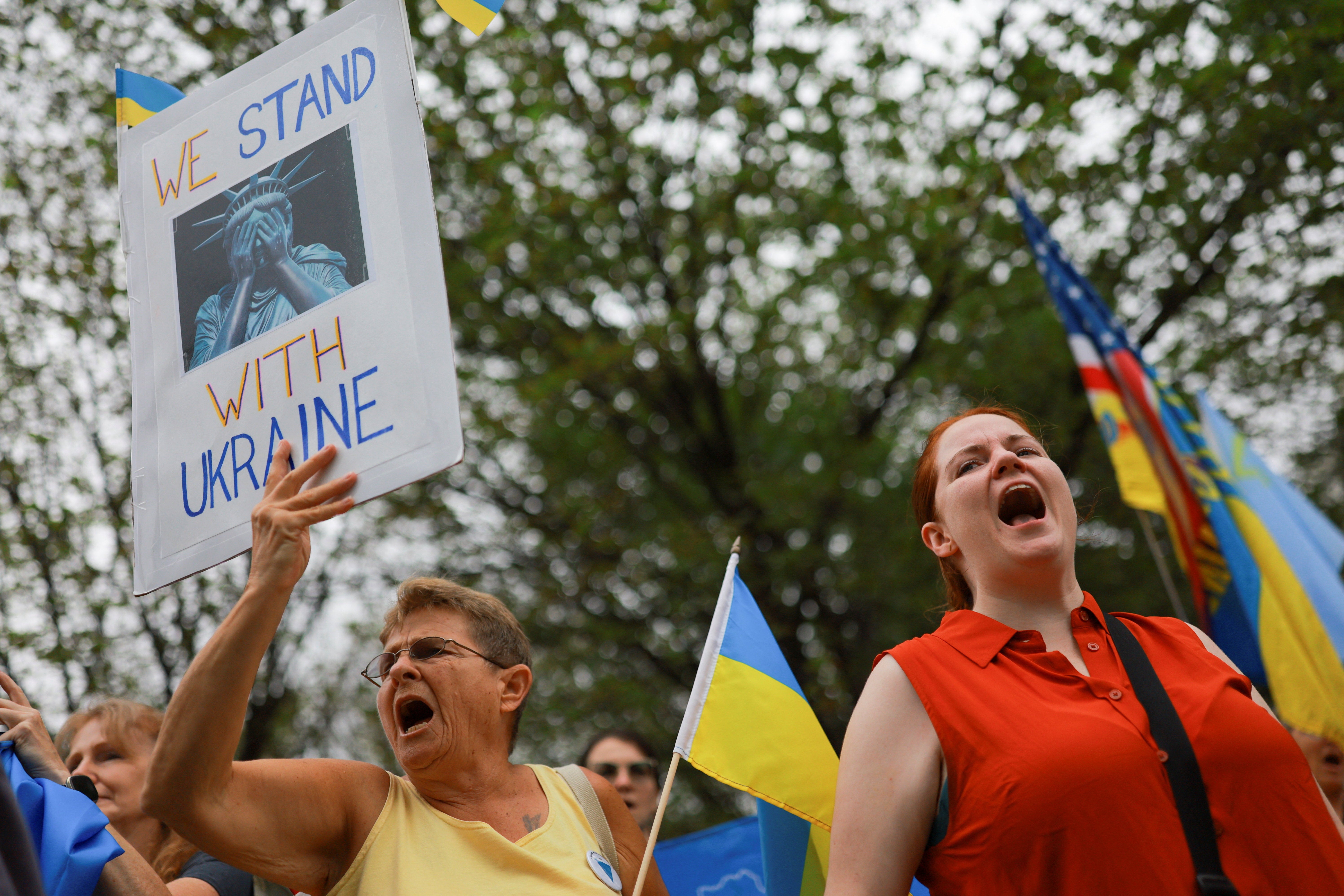 A pro-Ukraine demonstrator holds a sign that reads, 'We stand with Ukraine.' Trump and Zelensky are set to meet this afternoon in the Oval Office