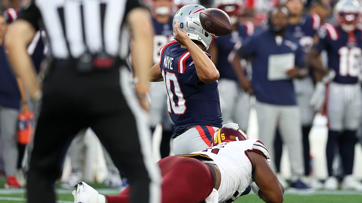 Washington Commanders defensive tackle Johnny Newton (95) tackles New England Patriots quarterback Drake Maye (10) during a preseason game at Gillette Stadium.