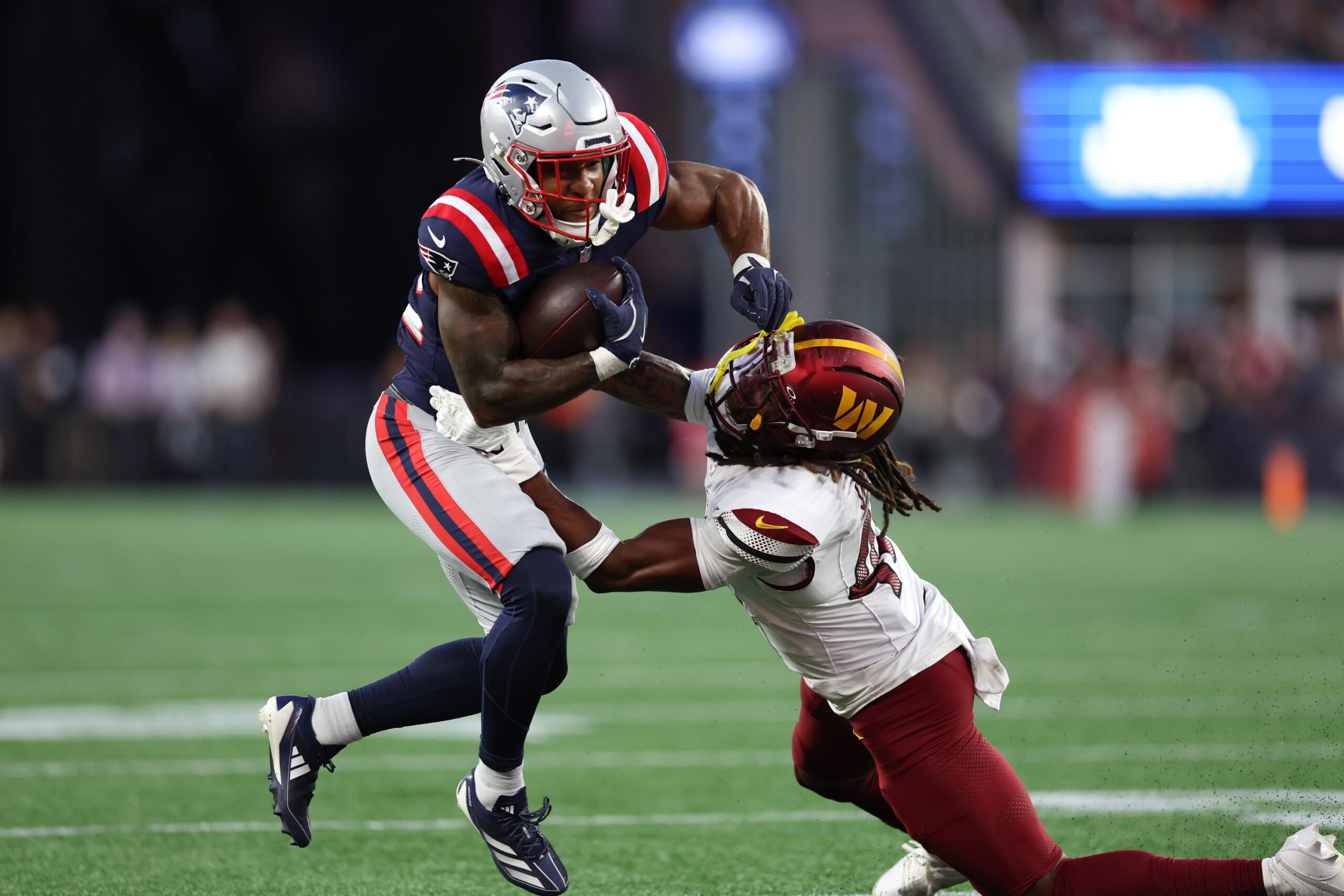 Aug 8, 2025; Foxborough, Massachusetts, USA; Washington Commanders saftey Tyler Owens (40) tries to tackle New England Patriots running back TreVeyon Henderson (32) during the first half at Gillette Stadium. Mandatory Credit: Paul Rutherford-Imagn Images