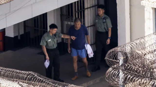 Jimmy Lai, center, exits his building to go for exercise at the Stanley prison in Hong Kong, Friday, Aug. 4, 2023