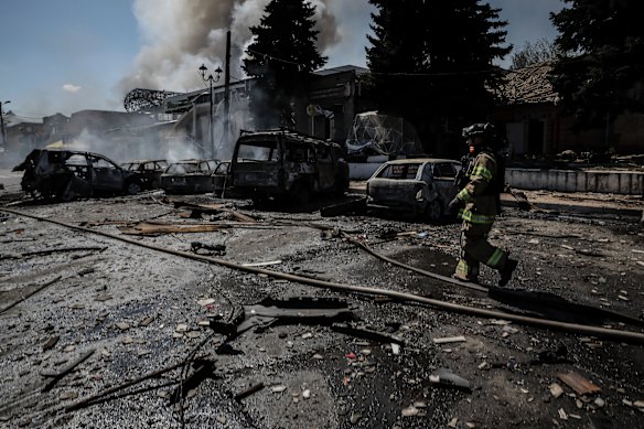 Firefighters put out a blaze after a Russian drone hit the market in the Donetsk town of Druzhkivka on August 2.