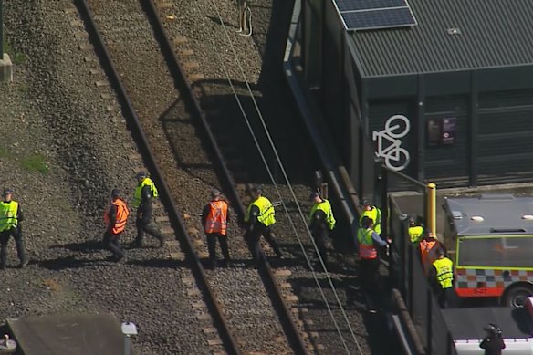 Police conduct a line search on the train tracks near Mount Druitt station. 