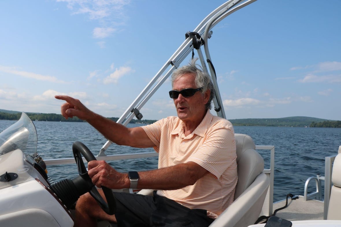 A man on a boat pointing ahead of him. 