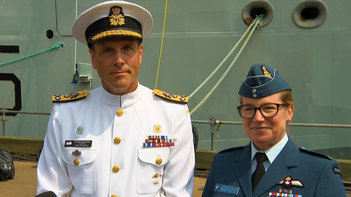 Topshee and Speiser-Blanchet stand in front of a new naval ship on the Halifax Harbour. 