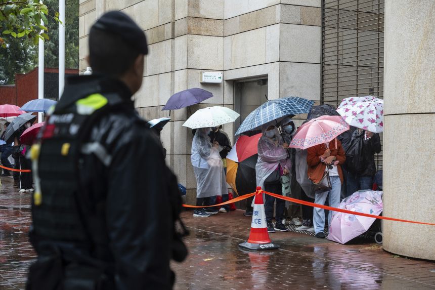 People wait to enter the West Kowloon Magistrates' Courts in Hong Kong on November 20, 2024, ahead of Hong Kong activist publisher Jimmy Lai's national security trial.