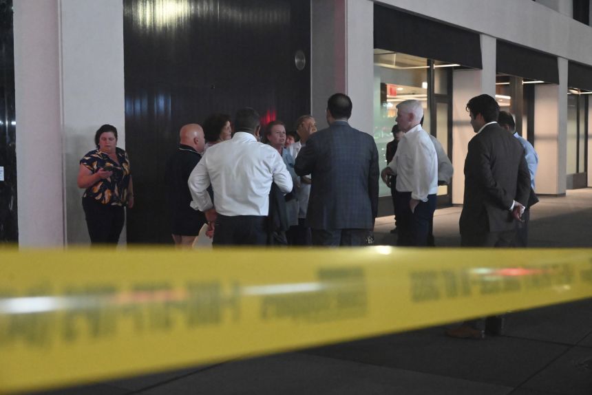 People exit the building to reunite with loved ones following a shooting at 345 Park Avenue in New York City on July 28.