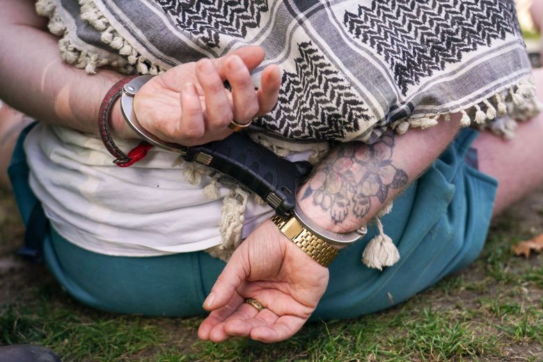 A demonstrator sits on the ground in handcuffs during the protest in London on Saturday.