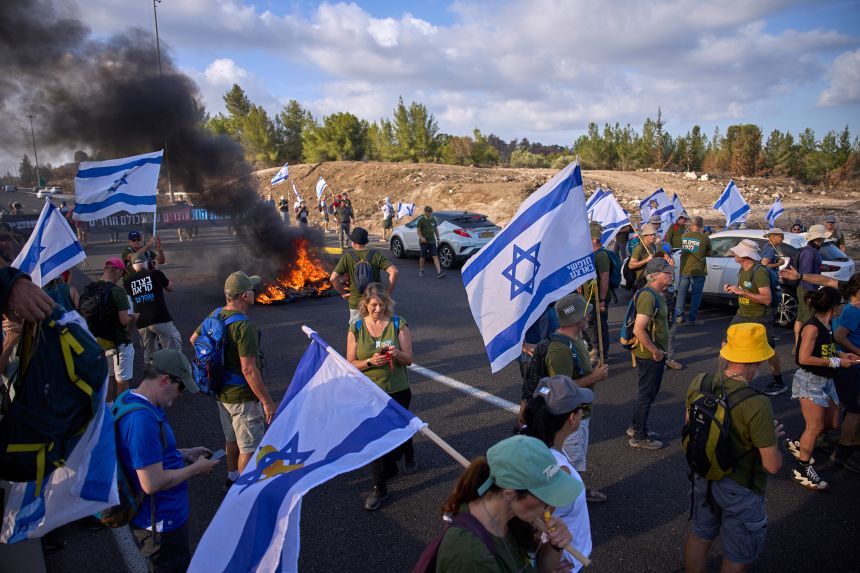 Demonstrators block a road during a protest demanding the immediate release of hostages held by Hamas and calling for the Israeli government to reverse its decision to take over Gaza City and other areas in the Gaza Strip, near Jerusalem, Israel, Sunday, Aug. 17, 2025.