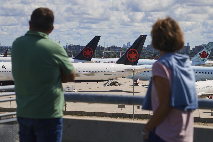 Travelers look out over grounded Air Canada planes as flight attendants picket at Pearson International Airport in Toronto, Canada on Monday.