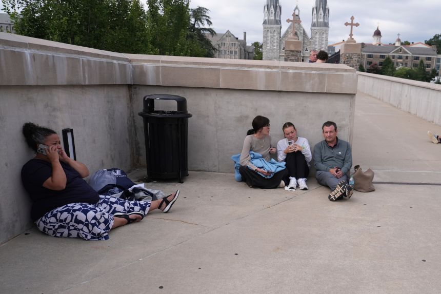 Students shelter behind a wall at the Villanova University campus where an active shooter was reported.