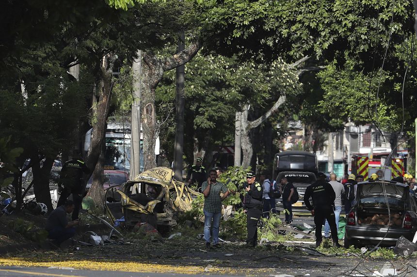 Security forces inspect the site of a bomb explosion outside an air base in Cali, Colombia, on Thursday.