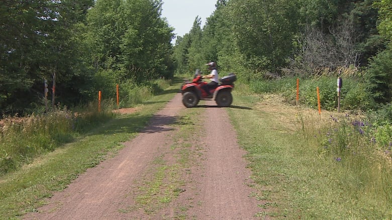 An all-terrain vehicle is seen on a trail in the woods.