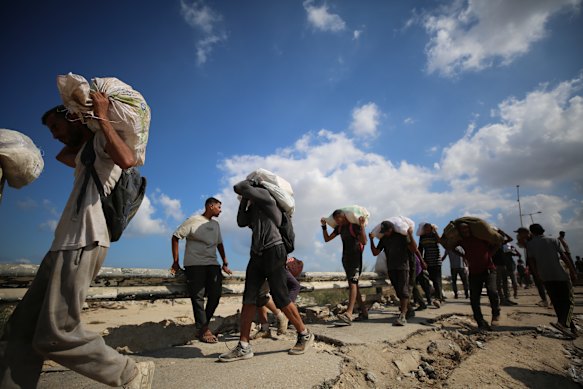 Palestinians flock to an aid distribution point set up in the Netzarim Corridor in hopes of receiving limited humanitarian aid in Deir al Balah, Gaza.