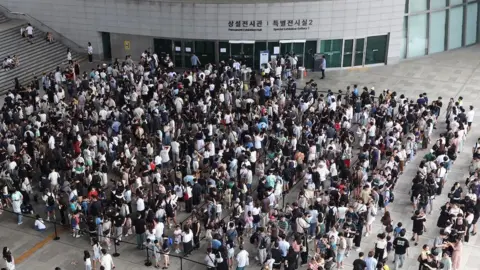 News1 View from above of a crowd queuing in front of a museum. They are guided into neat lines with cordons.