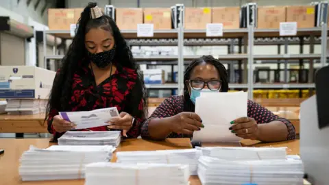Getty Images Women hold ballots in their hands