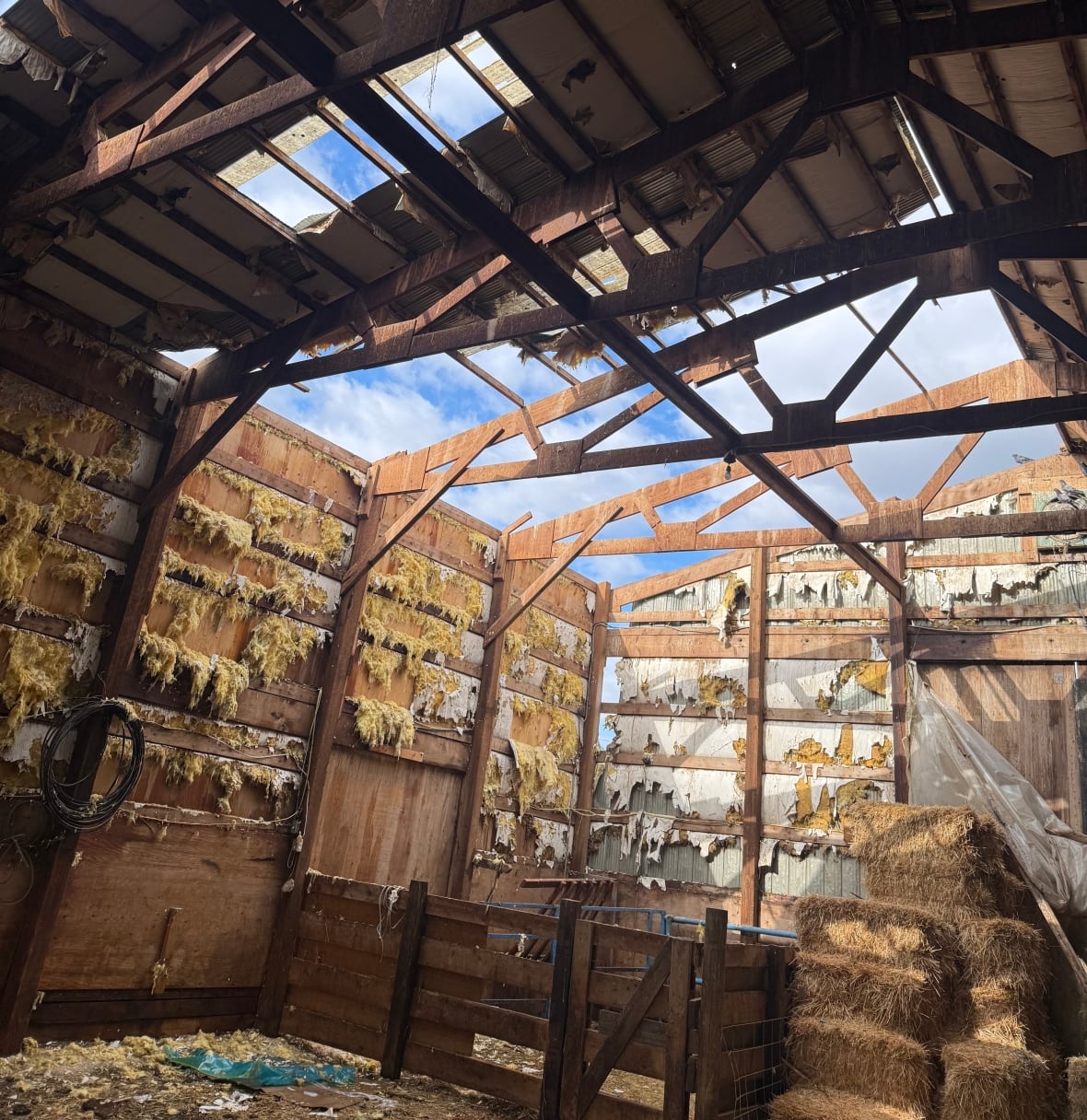 A barn with a damaged roof.