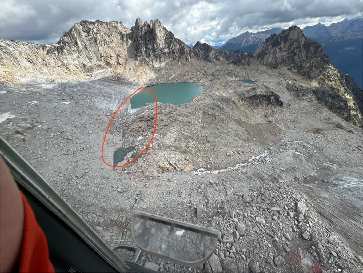 An alpine lake in the mountains shows a blockage highlighted in red.