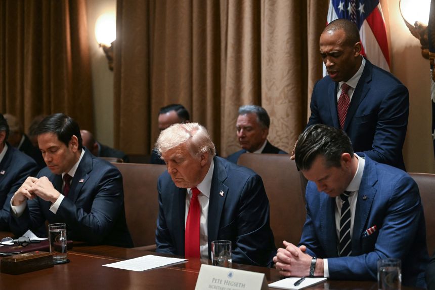 US Defense Secretary Pete Hegseth, right, prays with President Donald Trump and others during a cabinet meeting at the White House in Washington, DC, on February 26.