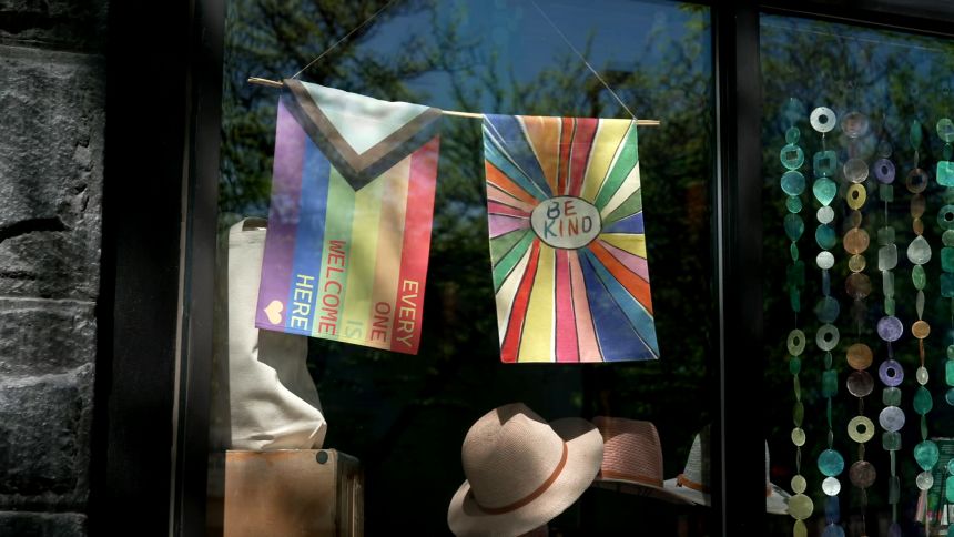 Pride and inclusivity flags hang in a show window in downtown Moscow, Idaho, where tensions run high between liberal-owned businesses and Kirker-owned businesses, which are owned by members of Christ Church.