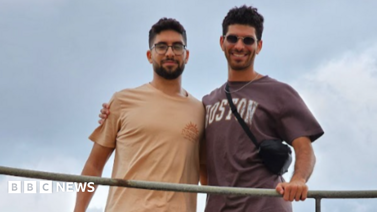 Evyatar David holds a pen and writes on a piece of paper as he crouches, emaciated, in a tunnel in Gaza