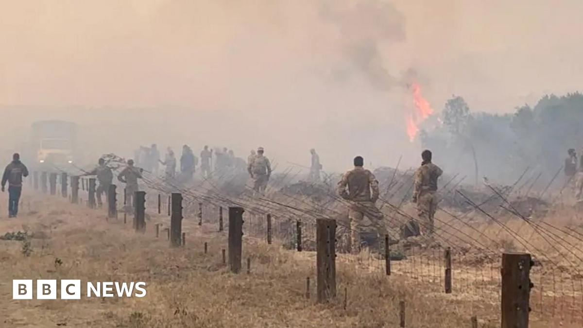 Workers look on as Kiruna's old wooden church is moved on giant trailers.