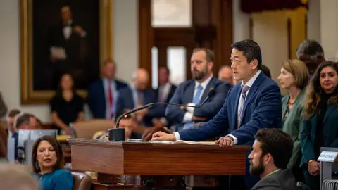 Getty Images Texas state lawmakers huddle in the House chamber 