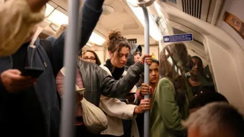 Getty Images passengers on board a crowded tube train.
