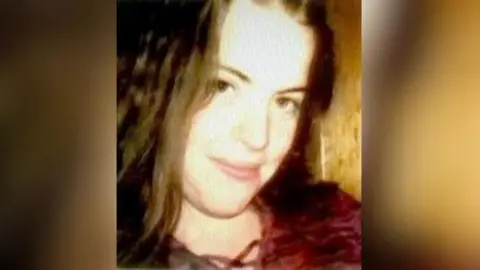 An Garda Síochána A photo of Fiona Sinnott taken around the time of her disappearance in 1998.  The 19-year-old had shoulder-length auburn hair and brown eyes and in the photo she is wearing a dark red top laced up at the neck.