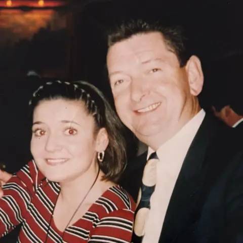 Patricia Conway A young woman in a red top with stripes next to a dark-haired man in a dark suit and tie