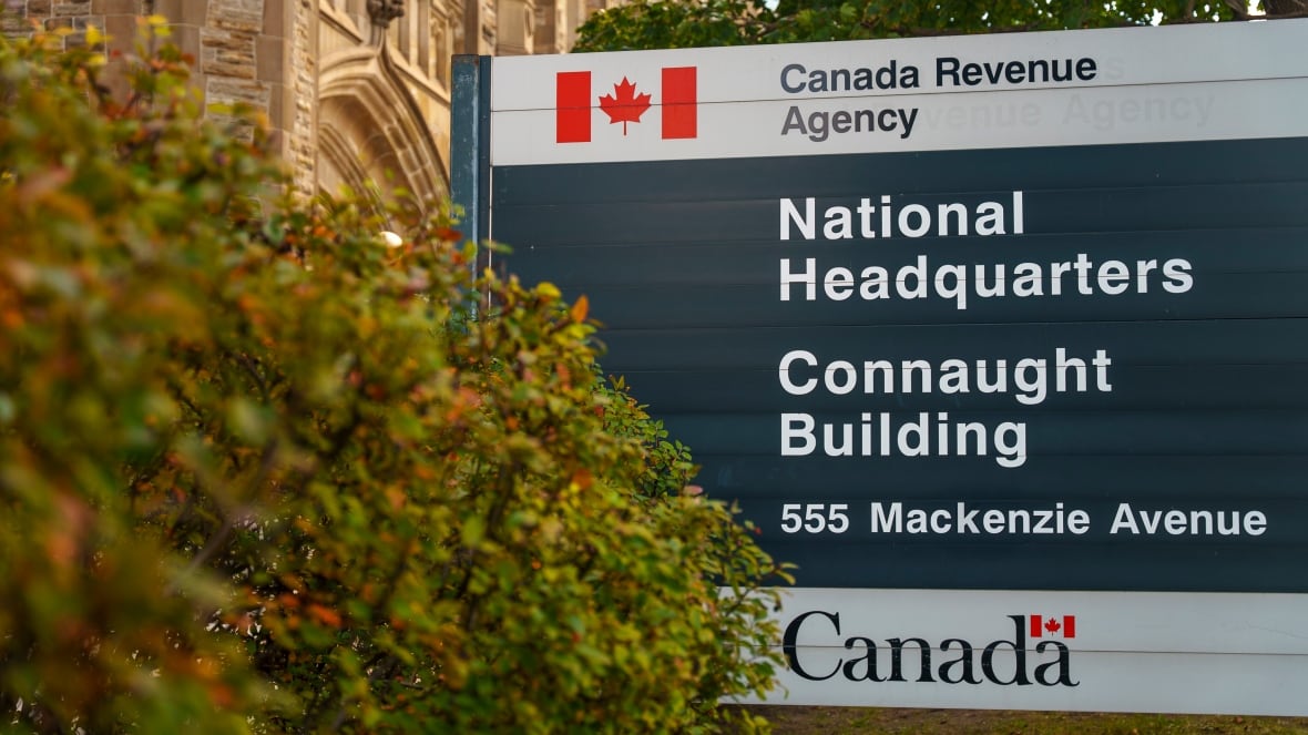 The exterior of a circa 1913 building with gothic and Tudor revival features with a sign outside that says Canada Revenue Agency, National Headquarters. Connaught Building.