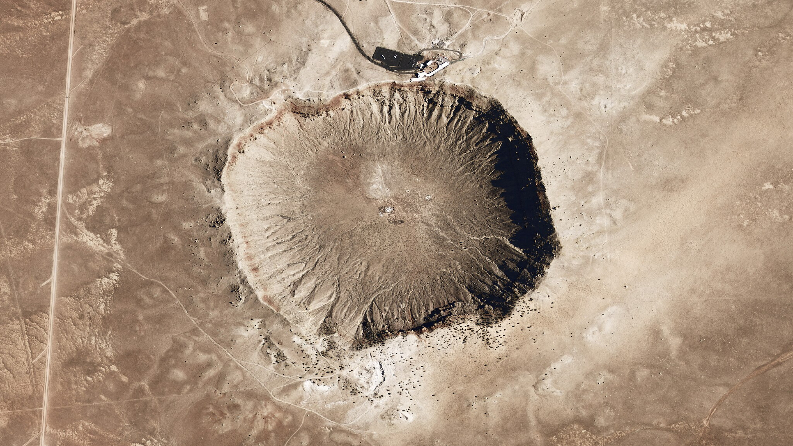 A large impact crater in Arizona looks like a bulge in a dusty landscape