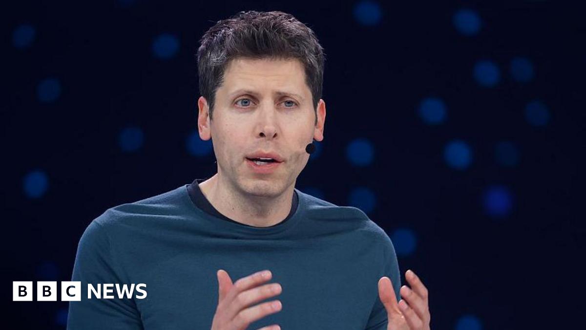 Sam Altman hearing a headset microphone on stage at an event