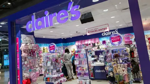 AFP via Getty Images A Claire's store in Paris, with it's purple logo, and array of colourful items inside the store on racks.