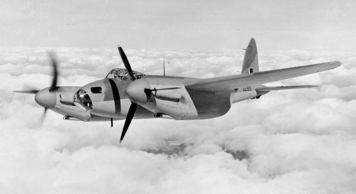 A black and white photo of a small combat propeller plane.