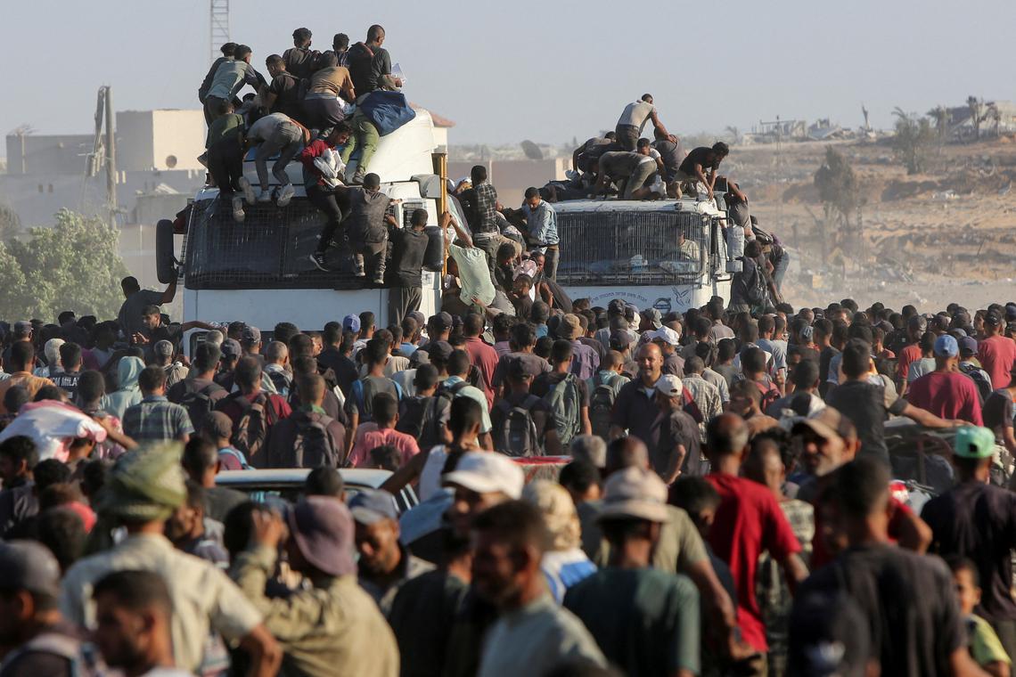 FILE PHOTO: Palestinians climb onto trucks as they seek aid supplies in Khan Younis, southern Gaza Strip, August 4, 2025. REUTERS/Hatem Khaled/File Photo