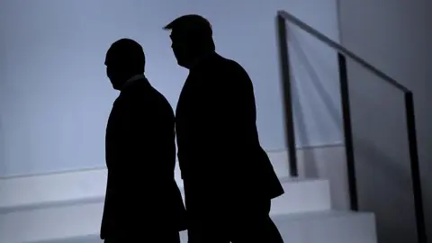 Getty Images Vladimir Putin and Donald Trump, silhouetted against the light, are seen walking side-by-side during the G20 summit in Osaka, Japan, in June 2019