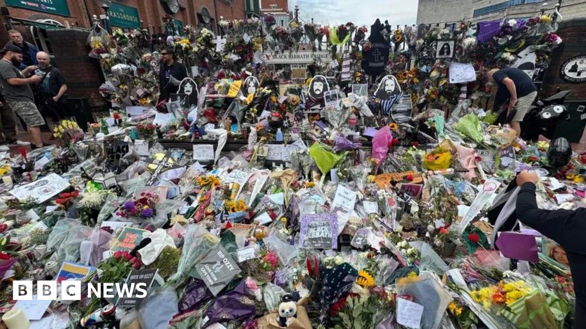 Hundreds of flowers and tributes to Ozzy Osbourne lie on the bench and floor on Black Sabbath Bridge.
