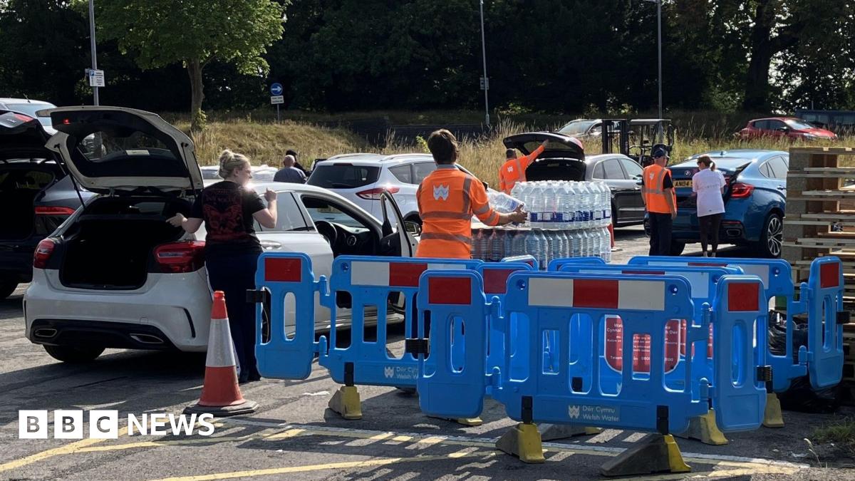 Fiona Lettsome in the driver seat of her car. She is smiling out the driver window and has short white hair. She is wearing sunglasses and a black t-shirt.