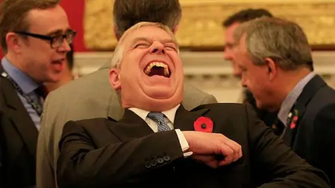 Getty Images Prince Andrew leans back laughing and exposing most of his upper teeth at a Pitch at the Palace event