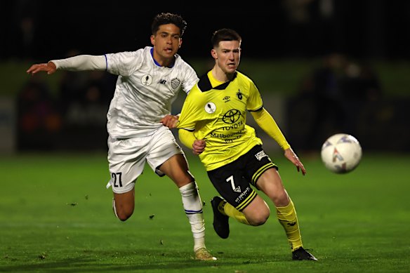 Fletcher Fulton of Heidelberg United FC is challenged by Logan Rogerson of Auckland FC.