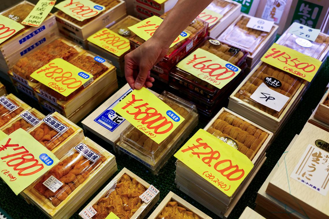 An employee at a wholesaler puts a price tag on a package of sea urchins from Hokkaido at Tsukiji Outer Market in Tokyo, Japan August 22, 2025. REUTERS/Issei Kato