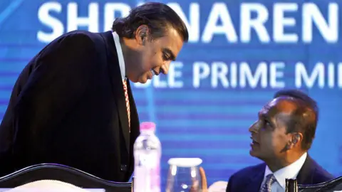 Getty Images Tycoon brothers Reliance Chairman Mukesh Ambani and Reliance ADA Group Chairman Anil Ambani during the launch of Digital India Week by Prime Minister Narendra Modi at IGI Stadium on July 1, 2015 in New Delhi, India. 