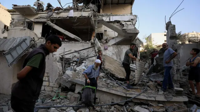 Palestinians inspect di site of overnight Israeli strike on onehouse, in Gaza City.
