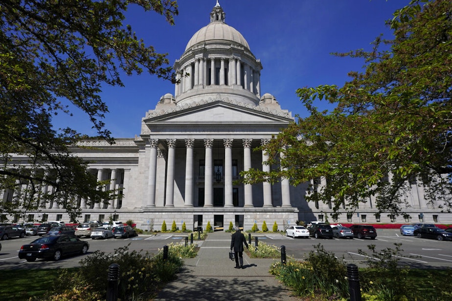 caption: A person walks near the Legislative Building, Wednesday, April 21, 2021, at the Capitol in Olympia, Wash. 
