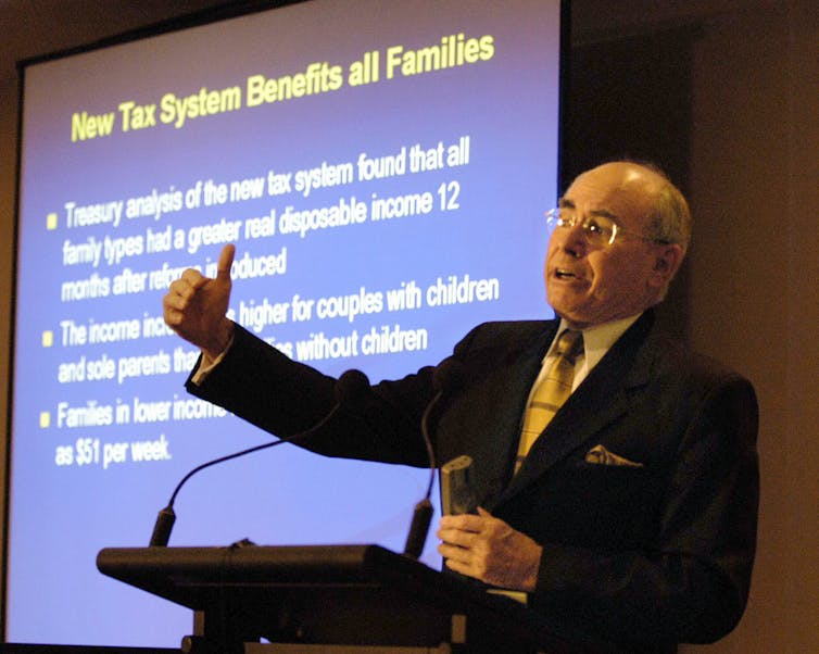 John Howard in 2003 stands in front of a tax presentation and gives a speech