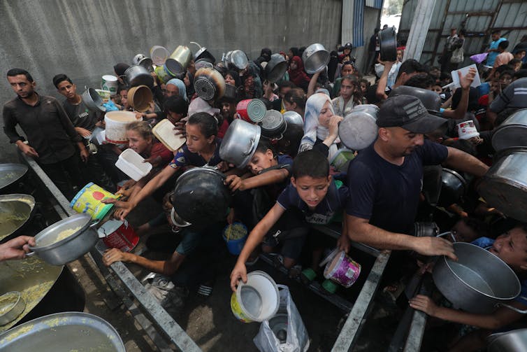 Children hold pots and pans.